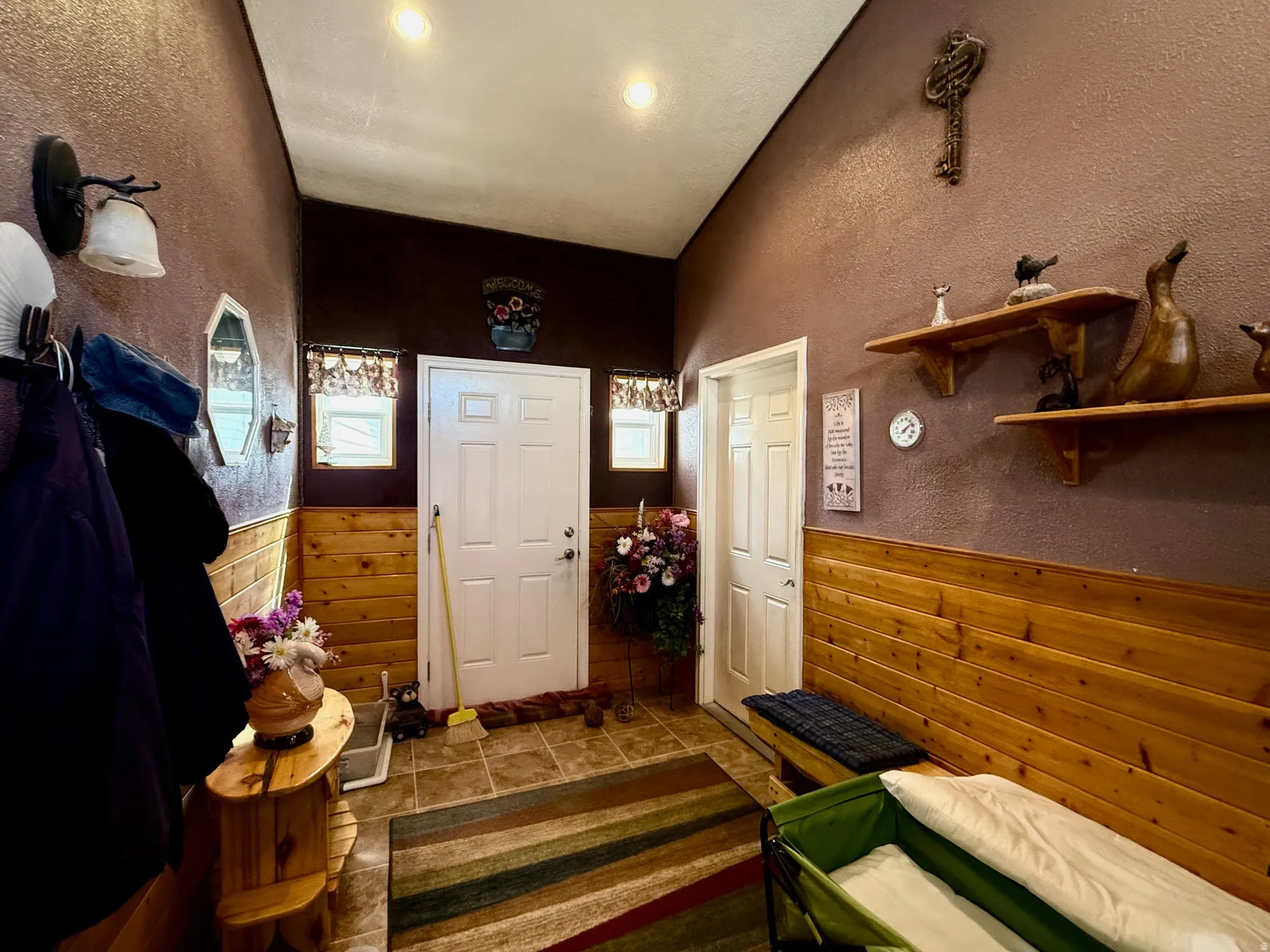 Foyer entrance featuring wainscoting, a textured wall, and dark tile patterned floors
