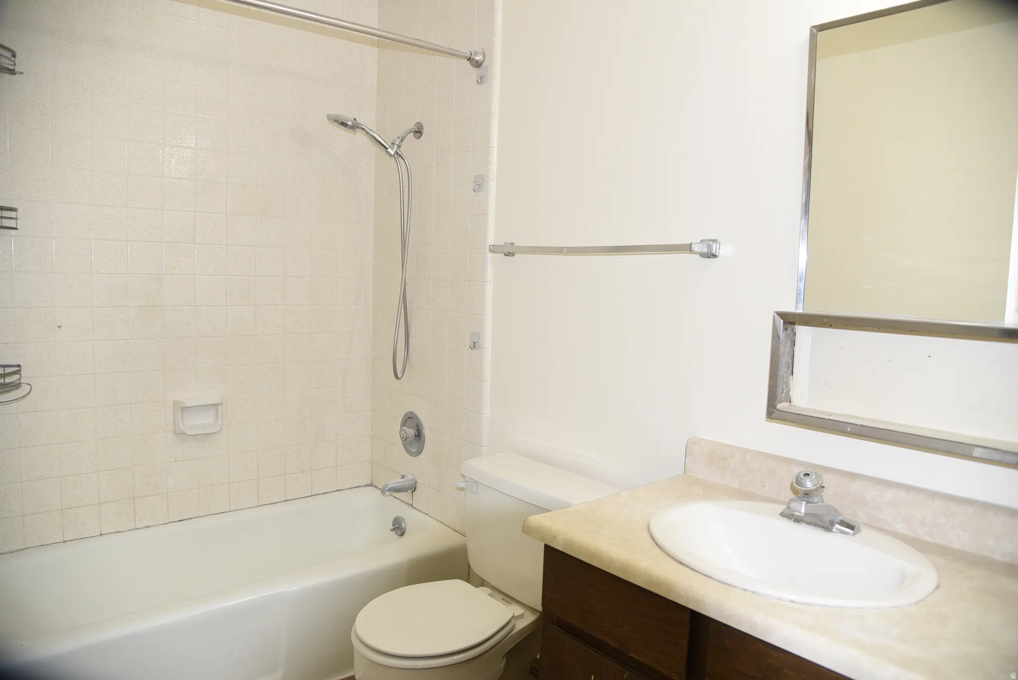 Bathroom featuring a tub/shower combination with white square tile surround, chrome fixtures, and a curved shower rod