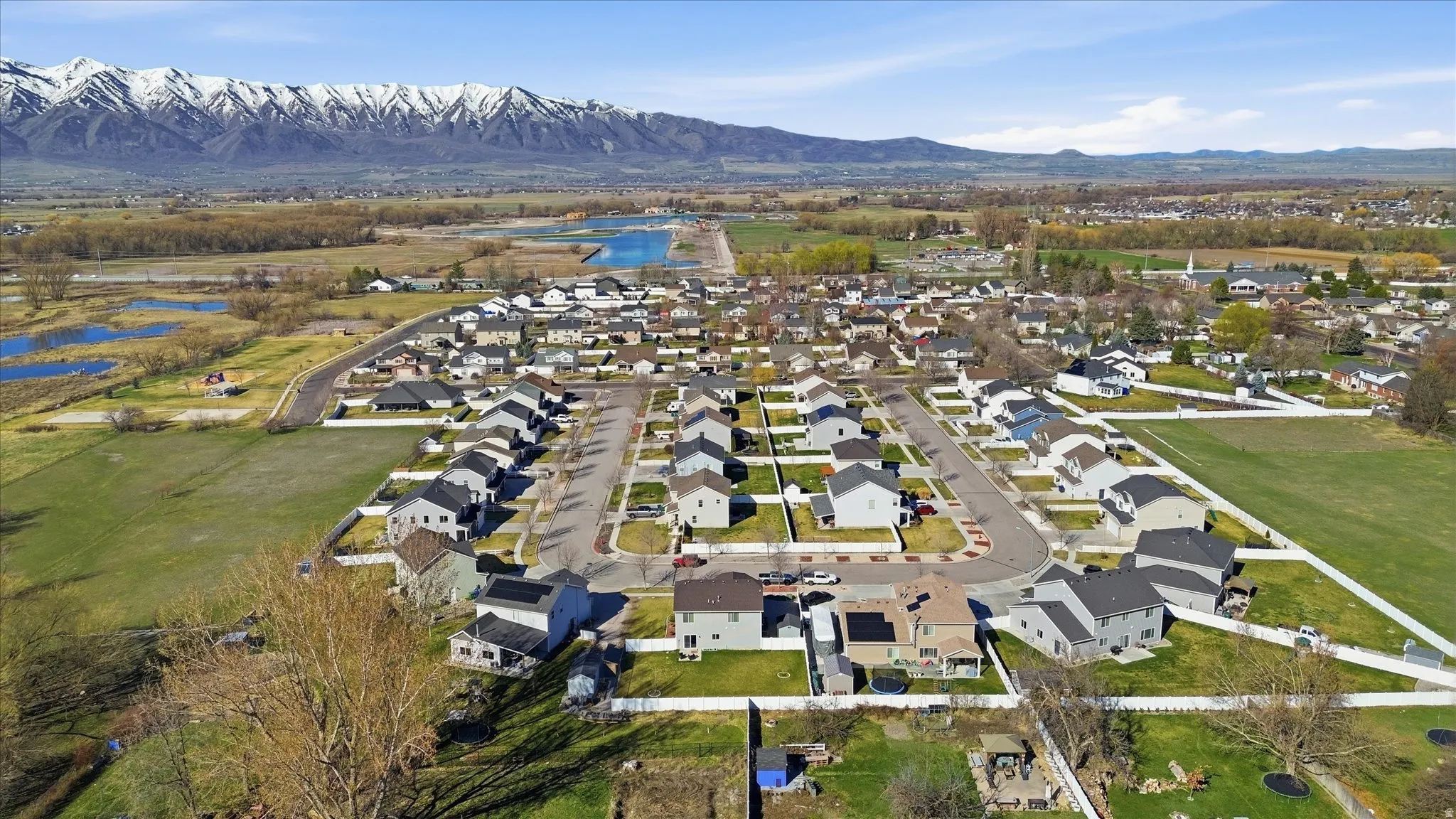 Aerial view of property and surrounding area with nearby suburban area and a water and mountain view