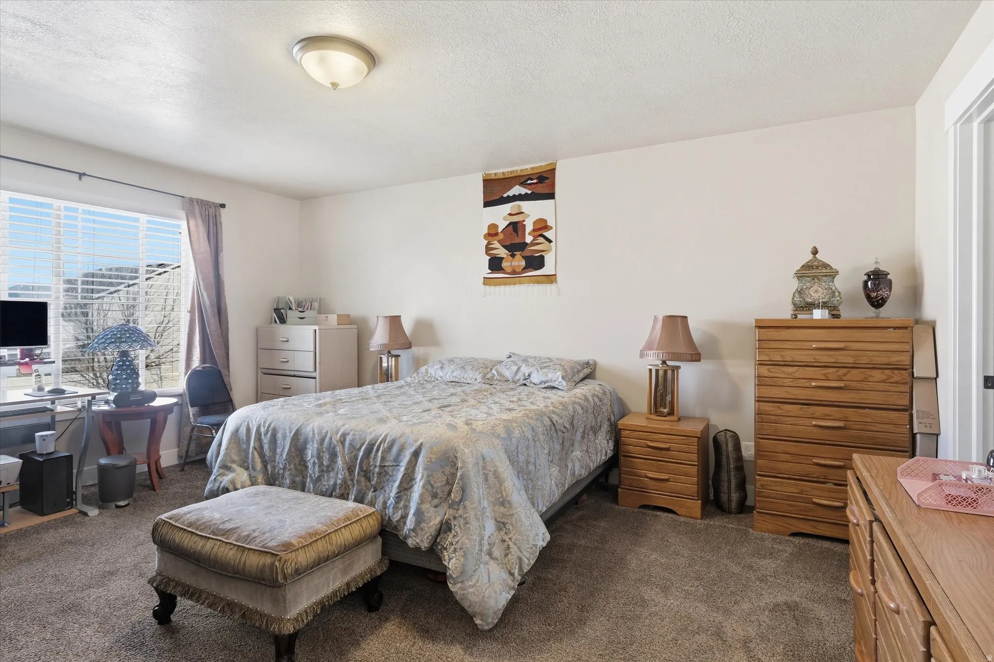Bedroom featuring dark carpet and a textured ceiling