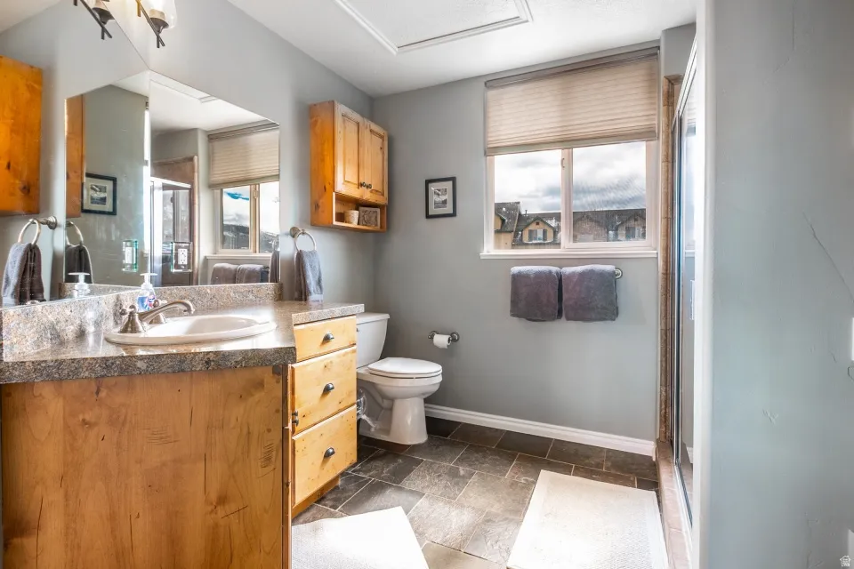 Bathroom featuring vanity, stone tile floors, and a stall shower