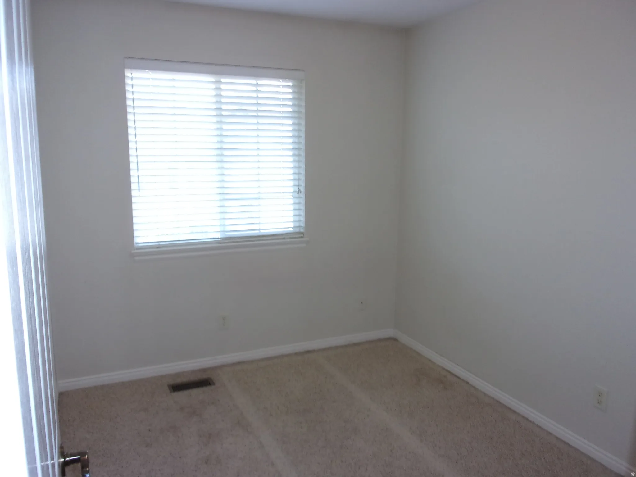 Spare room with light carpet and baseboards