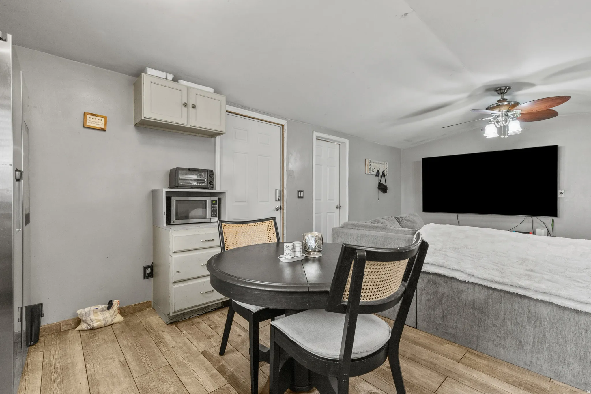 Dining area with ceiling fan, light wood-style flooring, and lofted ceiling
