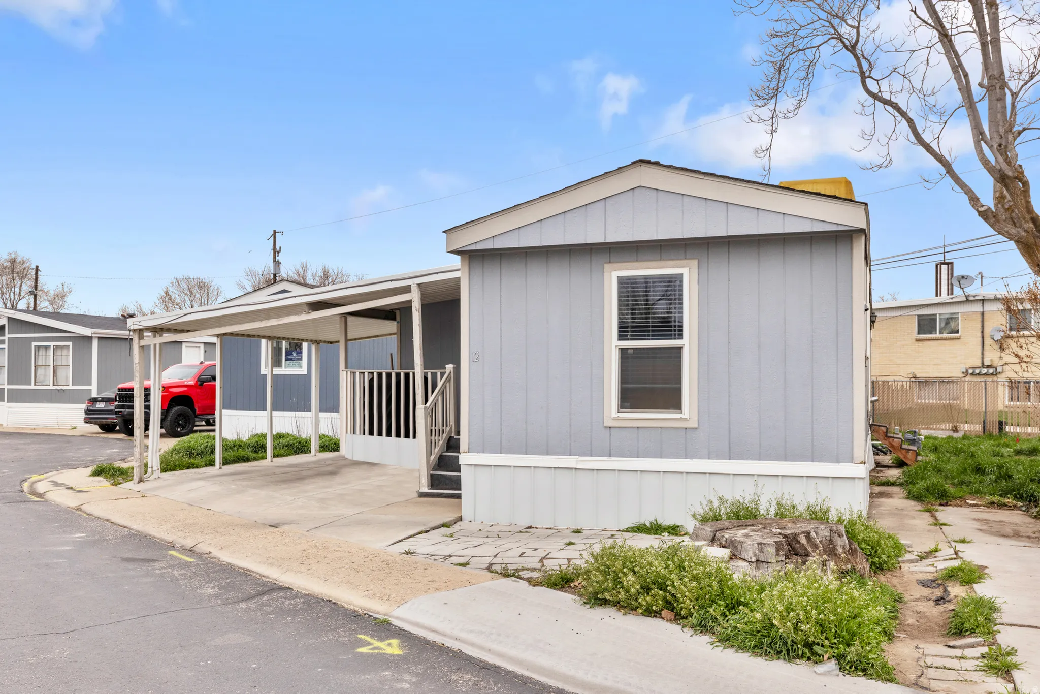 Manufactured / mobile home featuring an attached carport and driveway