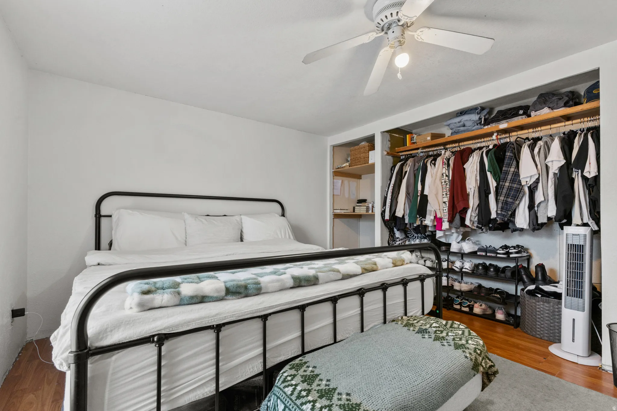 Bedroom with wood finished floors, ceiling fan, and a closet