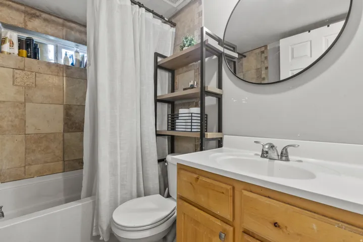 Bathroom featuring vanity and shower / bath combination with curtain