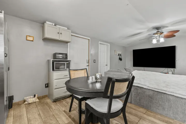 Dining area with ceiling fan, light wood-style flooring, and lofted ceiling
