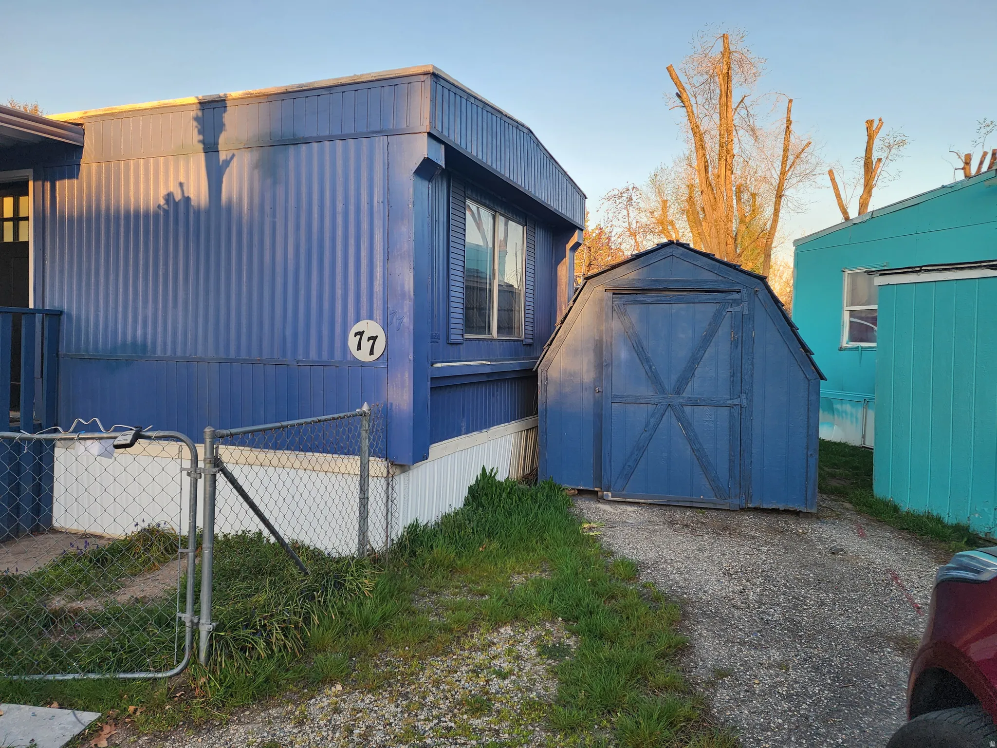 View of home's exterior featuring a gate and a storage shed