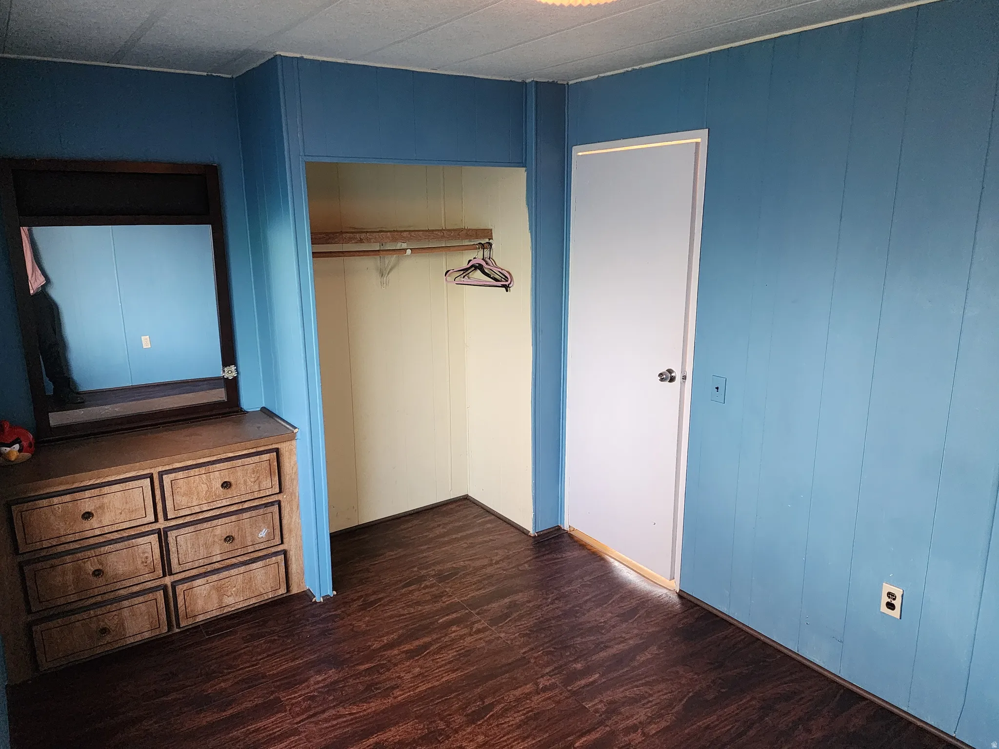Unfurnished bedroom with dark wood-style flooring and a closet
