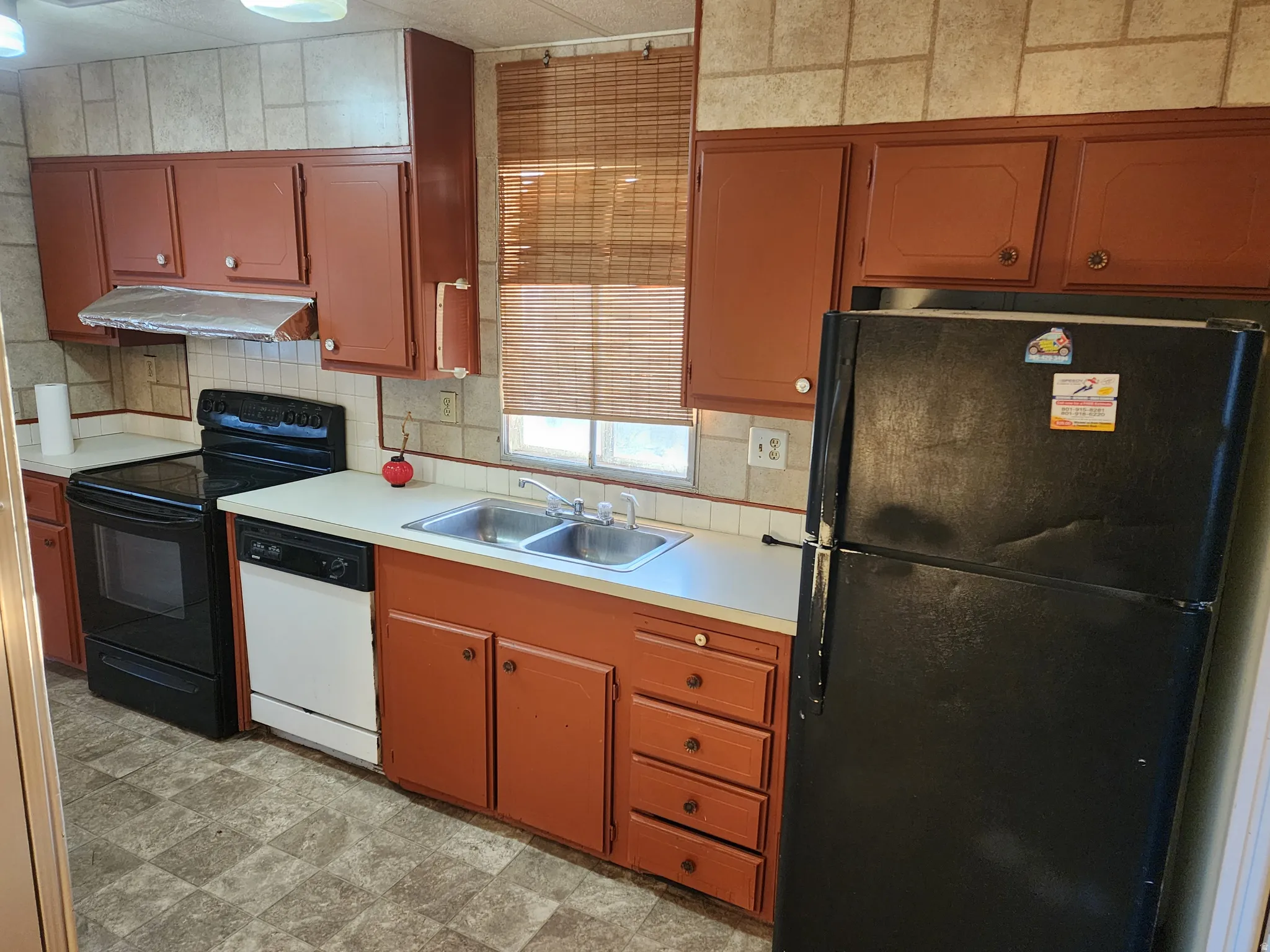Kitchen featuring black appliances, light countertops, and tasteful backsplash