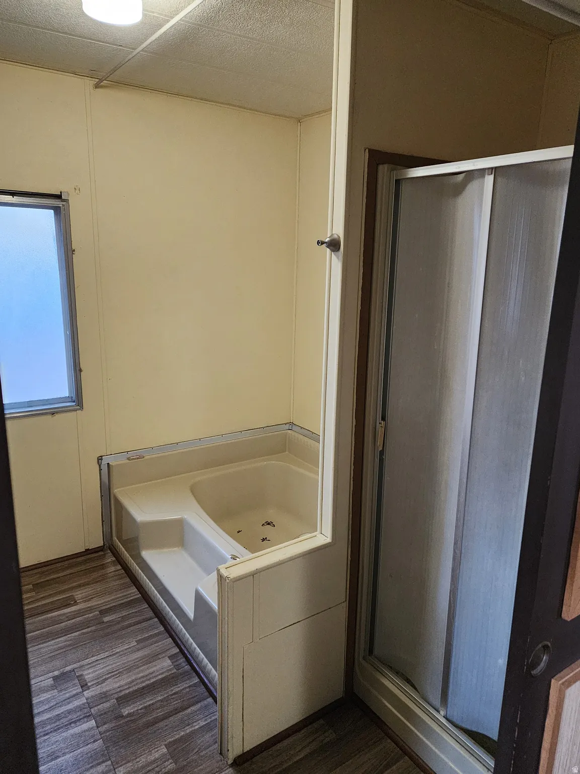 Full bathroom with a garden tub, a stall shower, and dark wood-type flooring
