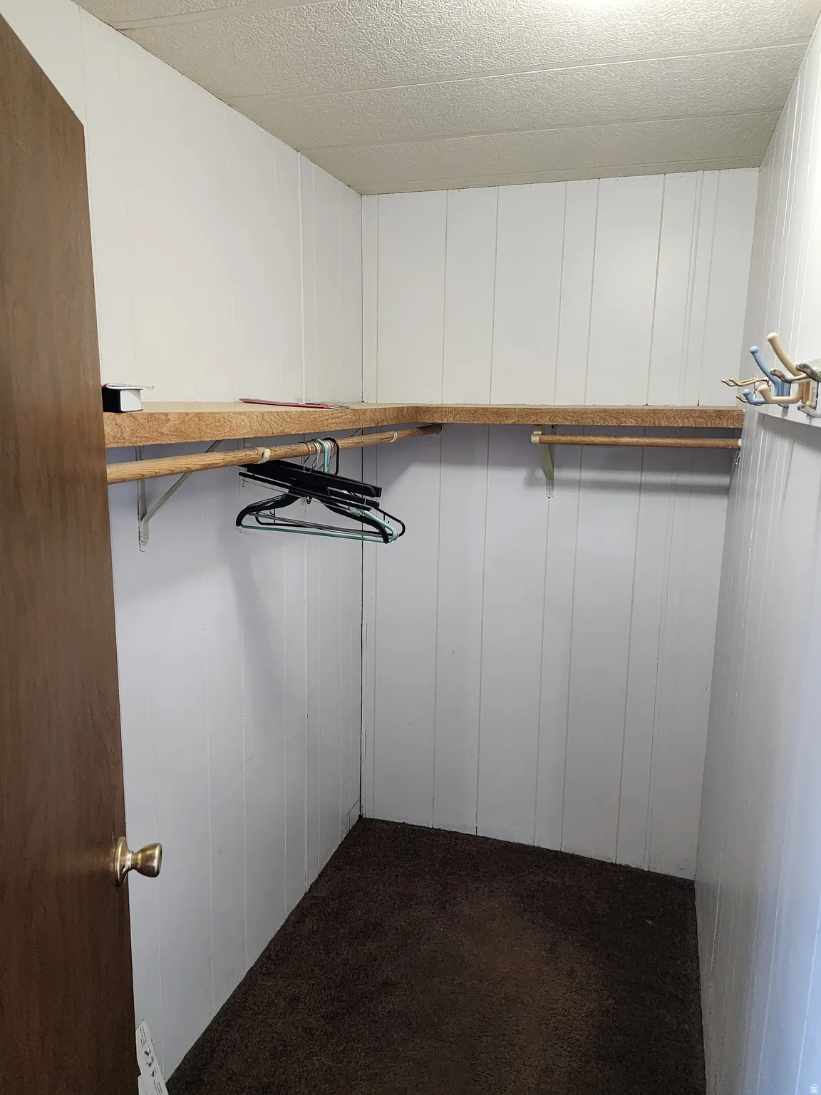 Walk in closet featuring dark carpet