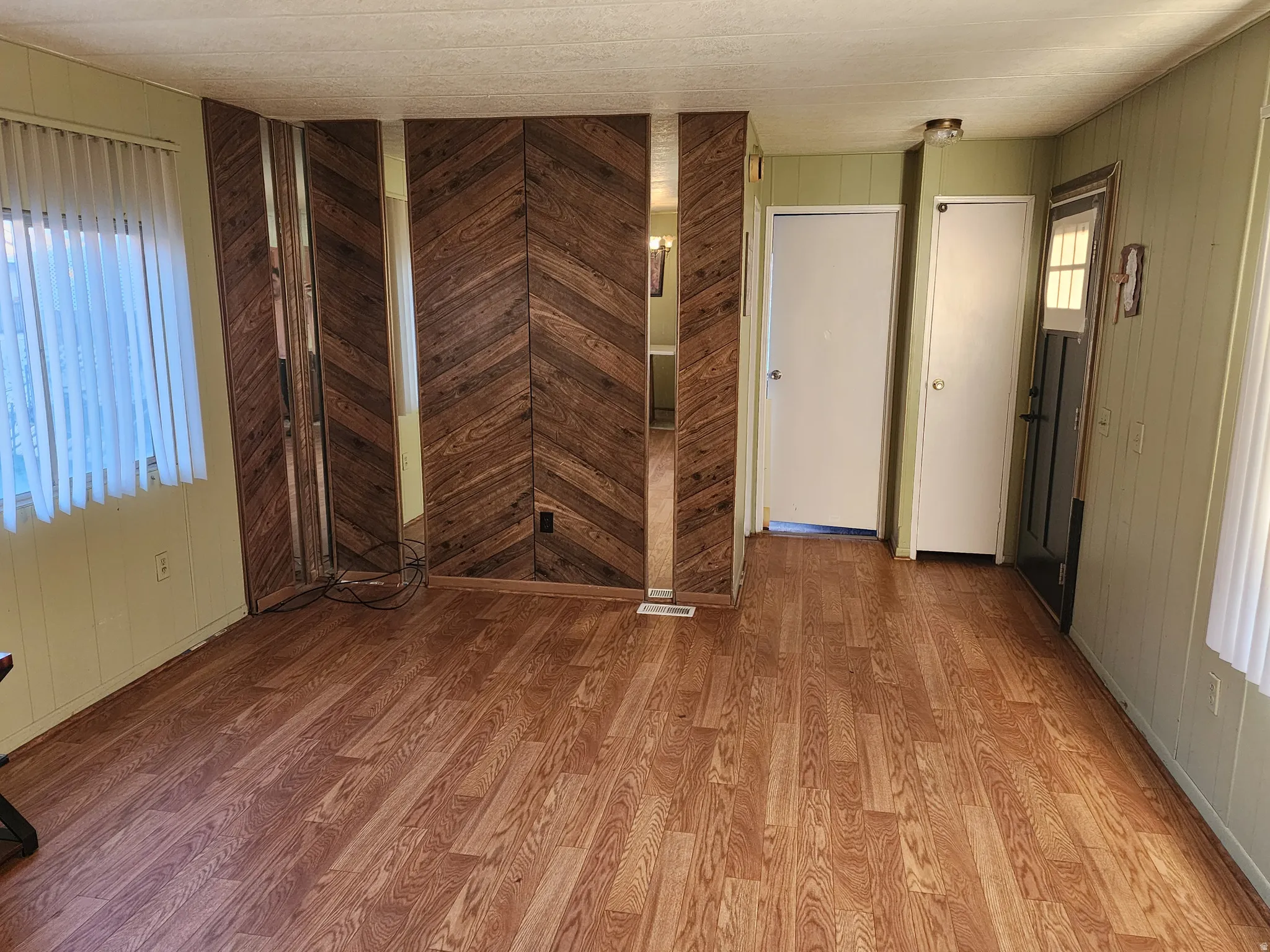Empty room featuring wood finished floors and wood walls
