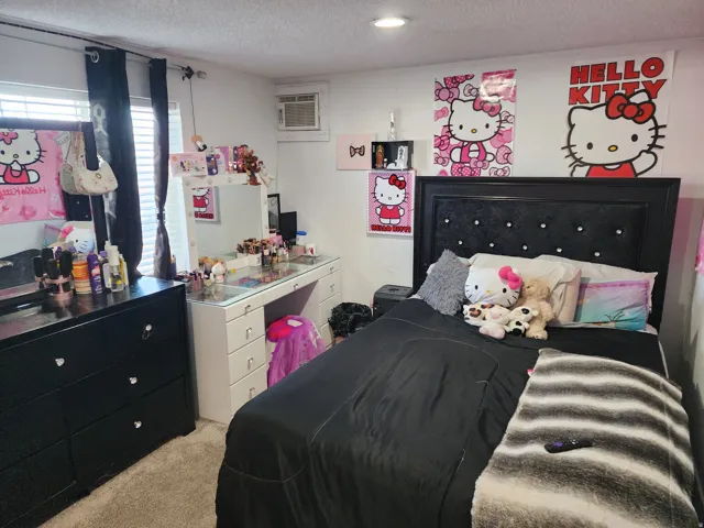 Bedroom with light colored carpet and a textured ceiling
