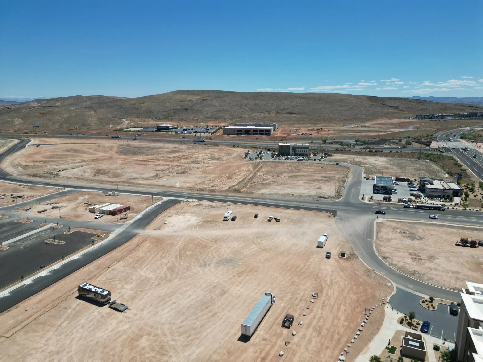 Aerial view of property and surrounding area featuring mountains and a desert landscape