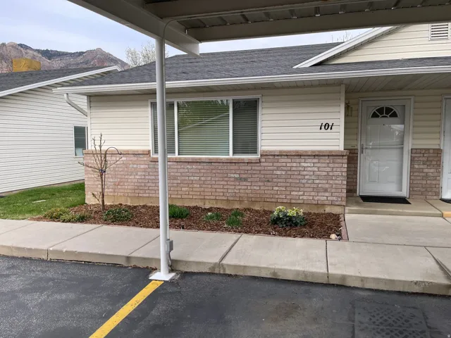 Entrance to property with brick siding, a shingled roof, and a mountain view