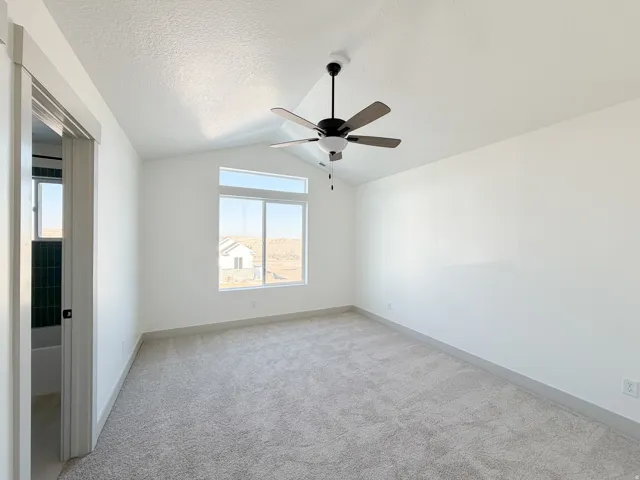 Bedroom 2 with private bathroom, light carpet, and a textured ceiling
