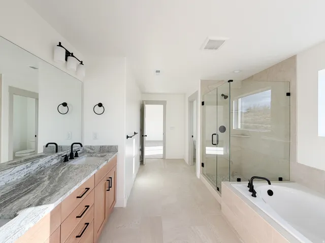 Primary Bathroom featuring vanity, a stall shower, and a bath