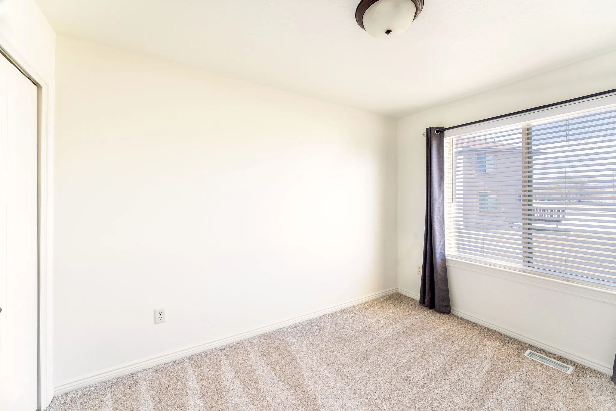 Spare room featuring light carpet and baseboards