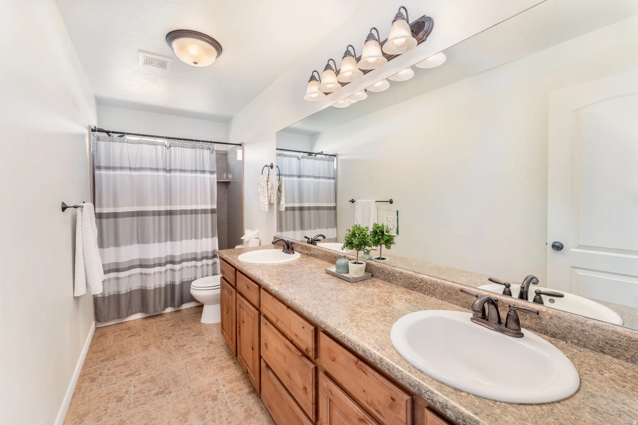 Full bathroom featuring double vanity and toilet