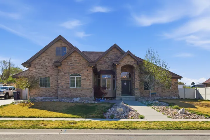 View of front of house with a gate and brick siding
