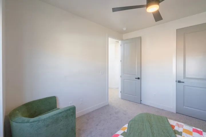 Bedroom with light carpet and a ceiling fan