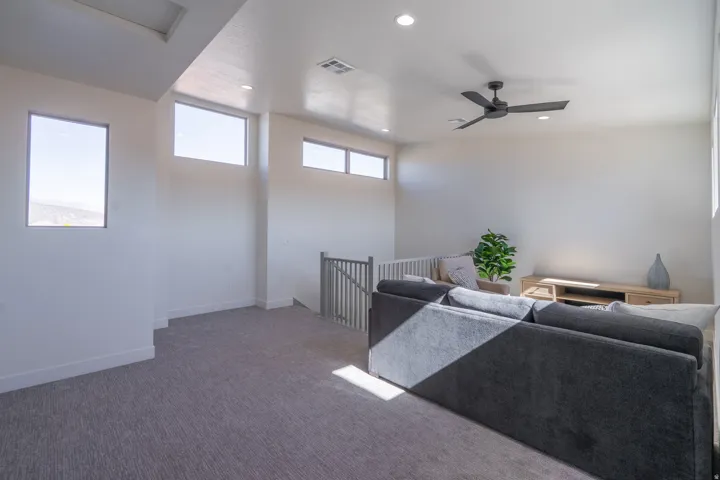 Carpeted living area featuring recessed lighting and ceiling fan