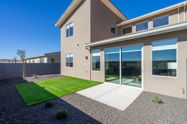 Rear view of property featuring a patio area, stucco siding, and a fenced backyard