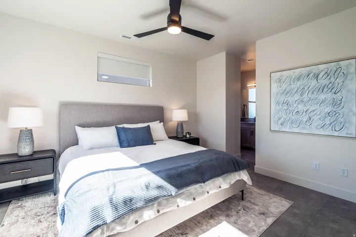 Bedroom featuring a ceiling fan and connected bathroom