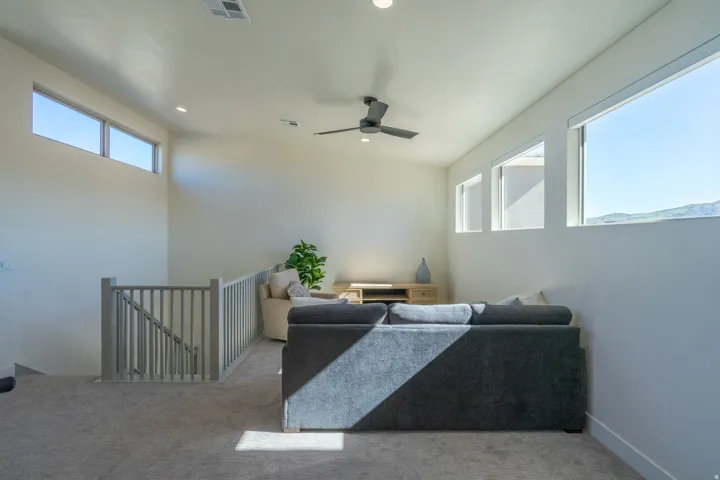 Living room featuring light colored carpet, plenty of natural light, ceiling fan, and recessed lighting