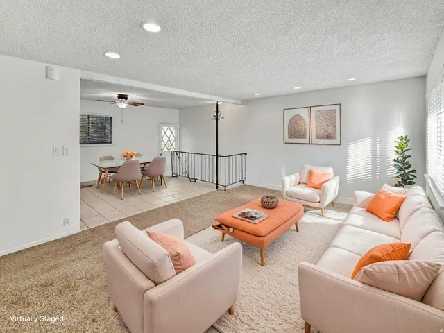 Living area featuring carpet floors, recessed lighting, a ceiling fan, a textured ceiling, and tile patterned flooring