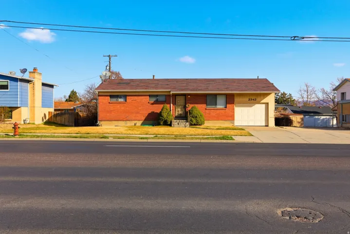 Ranch-style home with concrete driveway, brick siding, and an attached garage