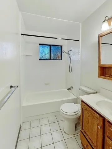 Bathroom featuring vanity, shower / tub combination, and light tile patterned floors