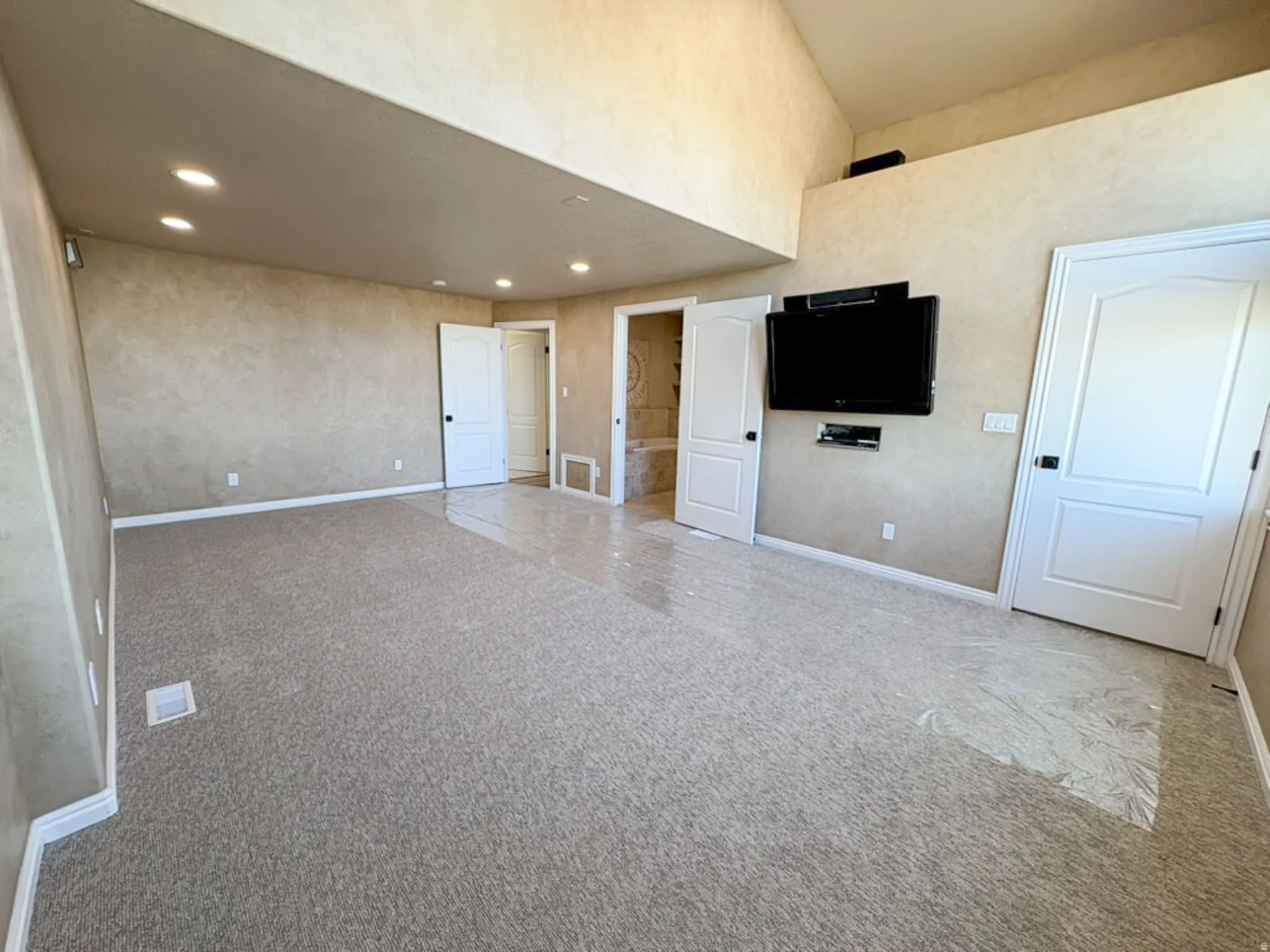 Unfurnished room with light carpet, recessed lighting, and a high ceiling