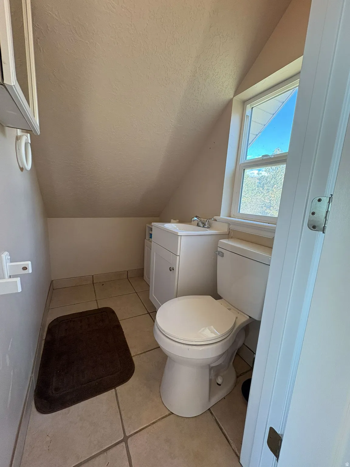 Half bathroom featuring light tile patterned floors and vanity