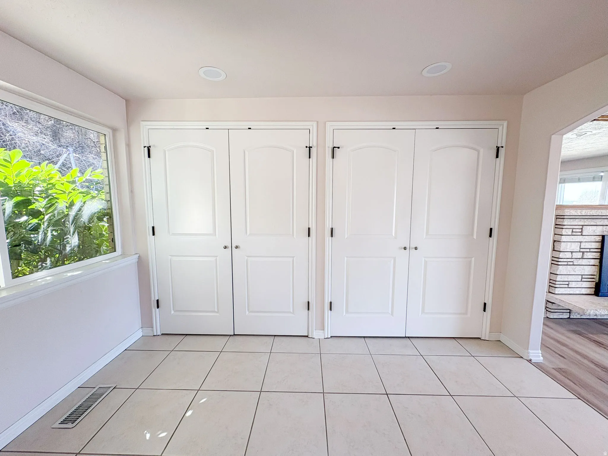 Unfurnished bedroom featuring light tile patterned floors and multiple closets