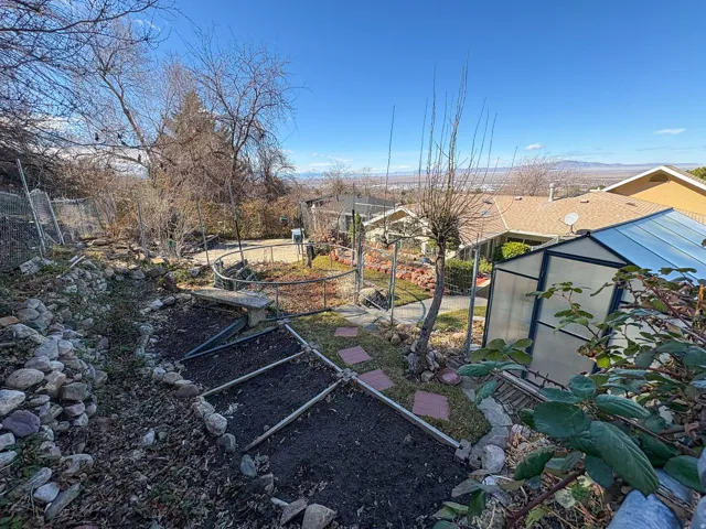 View of yard featuring an outbuilding, an exterior structure, and a garden