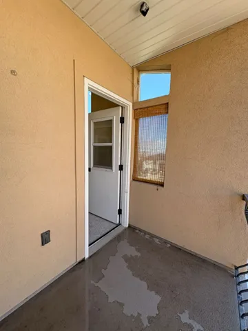 Doorway to property featuring stucco siding