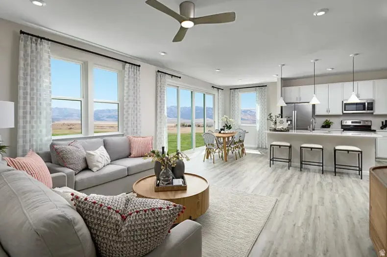 Living area with ceiling fan prewire, a mountain view, light wood-style flooring, and recessed lighting. Pictures are of a model home only! This home may feature different finishes than what is pictured.