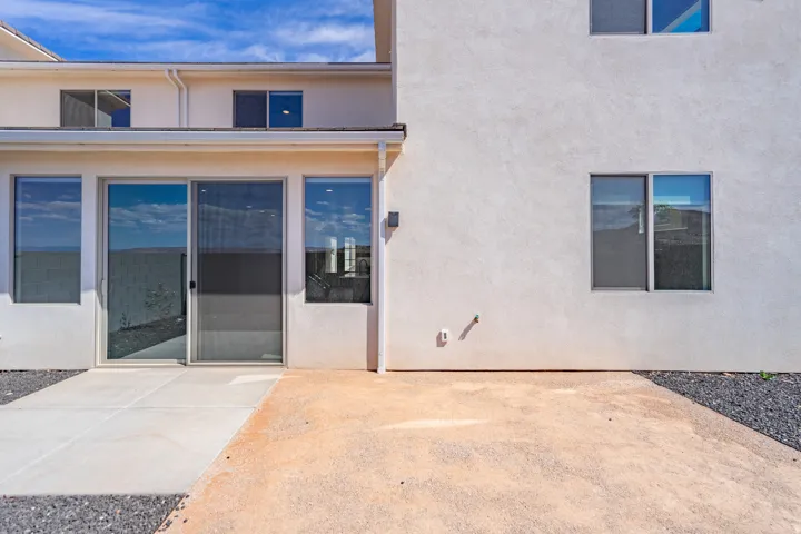 Stucco exterior featuring a ground-level patio with concrete and gravel sections