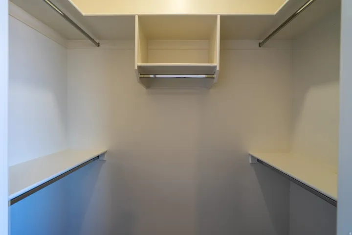 Walk-in closet with white walls and built-in shelving