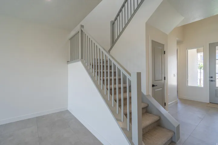 Modern staircase with carpeted treads and painted balusters