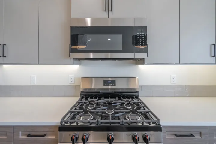 Stainless steel gas range with a coordinating microwave and range hood