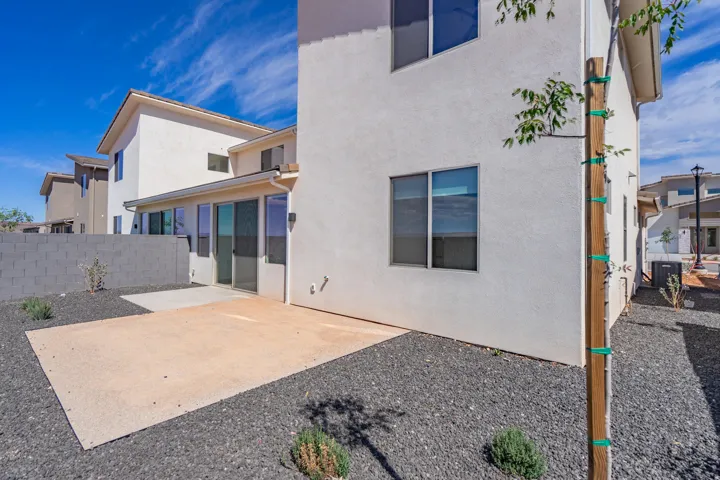 Stucco exterior with multiple windows and a sliding glass door