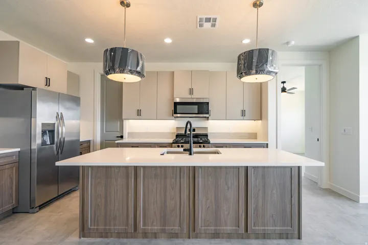 Contemporary kitchen featuring a spacious island with a white countertop and wood-finish cabinetry