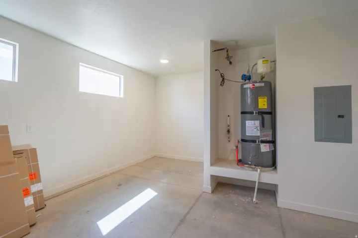 Bright, unfinished space featuring multiple windows, a recessed ceiling light, and a concrete floor
