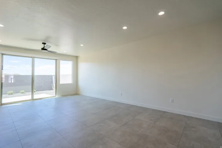 Spacious room featuring neutral-toned walls, recessed lighting, and large format tile flooring