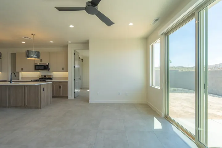 Open-concept living area with light-toned tile flooring and a ceiling fan