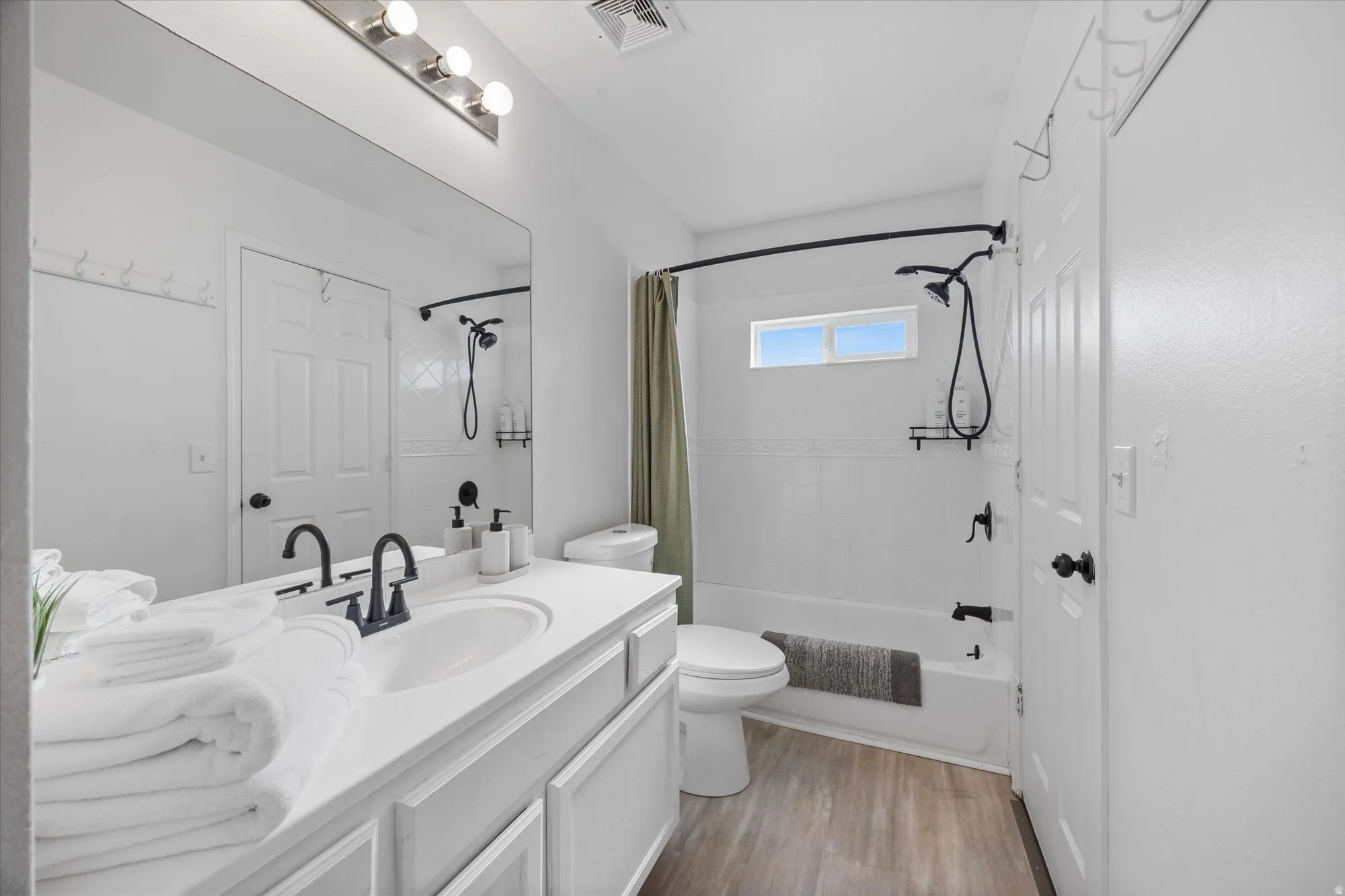 Bathroom featuring vanity, light wood-type flooring, and shower / bath combo