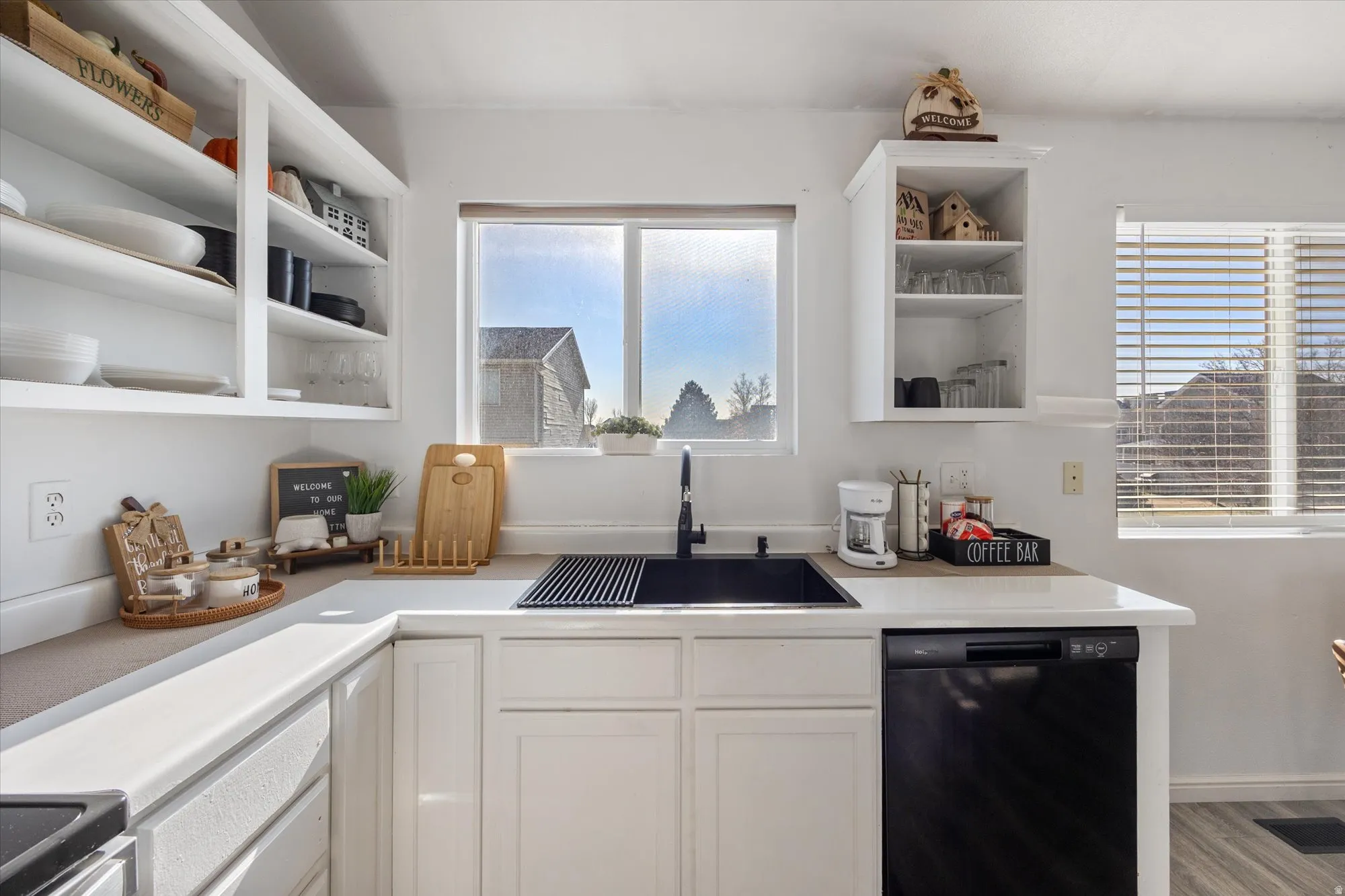 Kitchen featuring open shelves, dishwasher, and white cabinetry